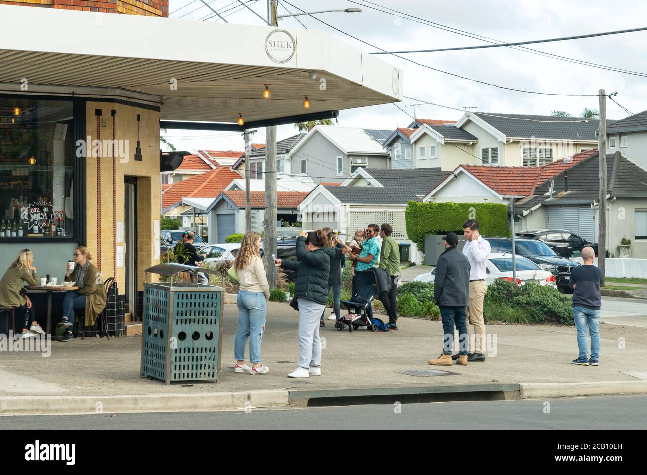 Sydney NSW Australien - 27. Mai 2020 - Cafeteria Shuk Kunden warten draußen an einem bewölkten Herbstnachmittag nach easy Die absperrenden Rasenflächen Stockfoto
