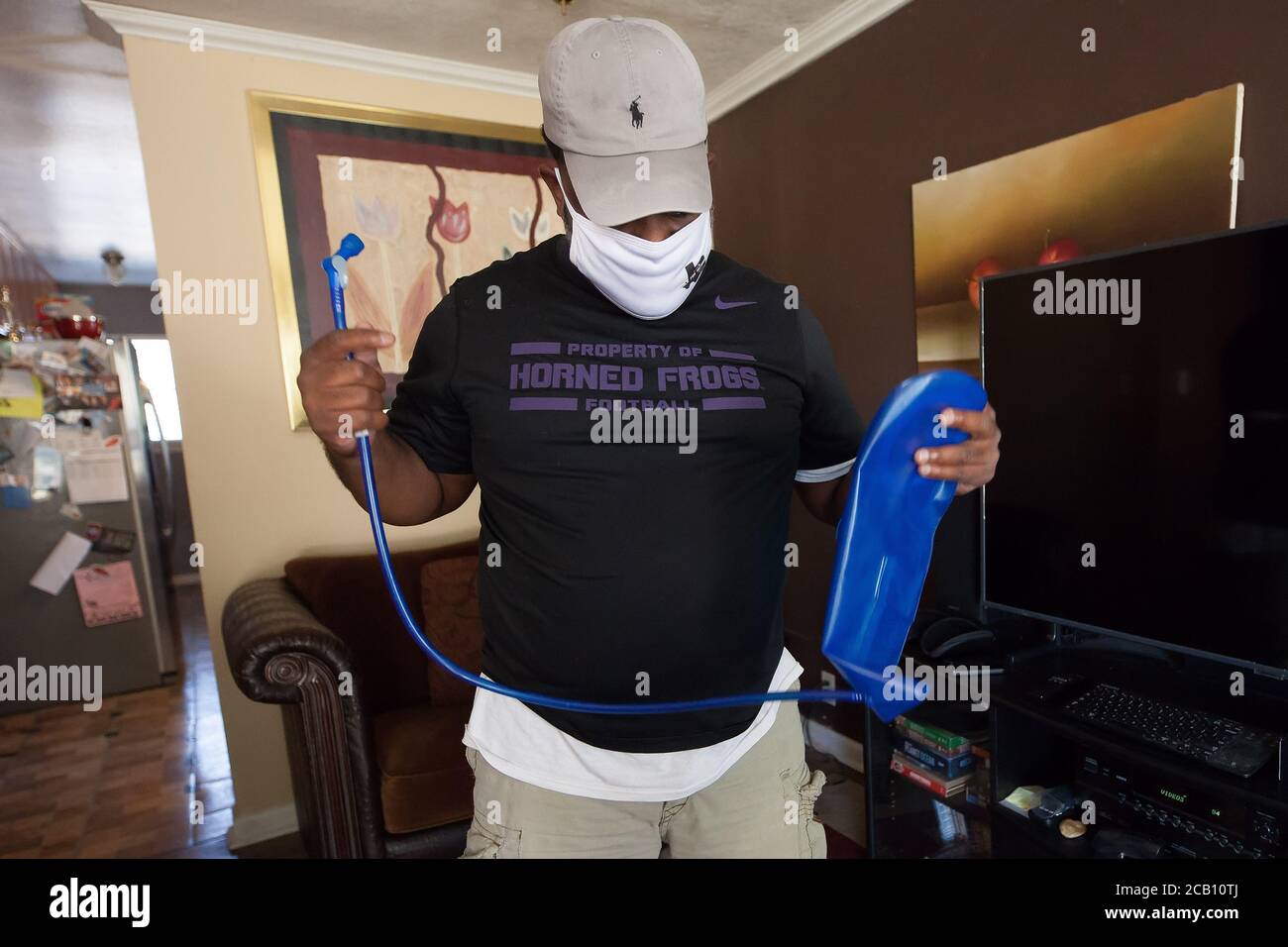 Ft Worth, TX, USA. August 2020. 8. August 2020: Leon Reed, Jr, hält seinen Wasserrucksack hoch, den er mit sich bringen wird, als er sich auf einen 200 Meilen langen Spaziergang von Ft Worth nach Austin, TX, aufmacht, um einen Brief zu überbringen und seine Gedanken zur Polizeireform mit Gov zu besprechen. Greg Abbott. Da er nicht sicher ist, wann er ankommen wird, hat er noch kein Treffen mit dem Gouverneur eingerichtet. Abbott, und er hofft, dass der Gouverneur ihn sehen wird. Leon ist seit 16 Jahren Strafverteidiger in Ft Worth und hofft, dass seine Ideen zu Veränderungen führen werden. Der Name seines Spaziergangs heißt Walk for Reform. (Bild: © Leslie Spurloc Stockfoto