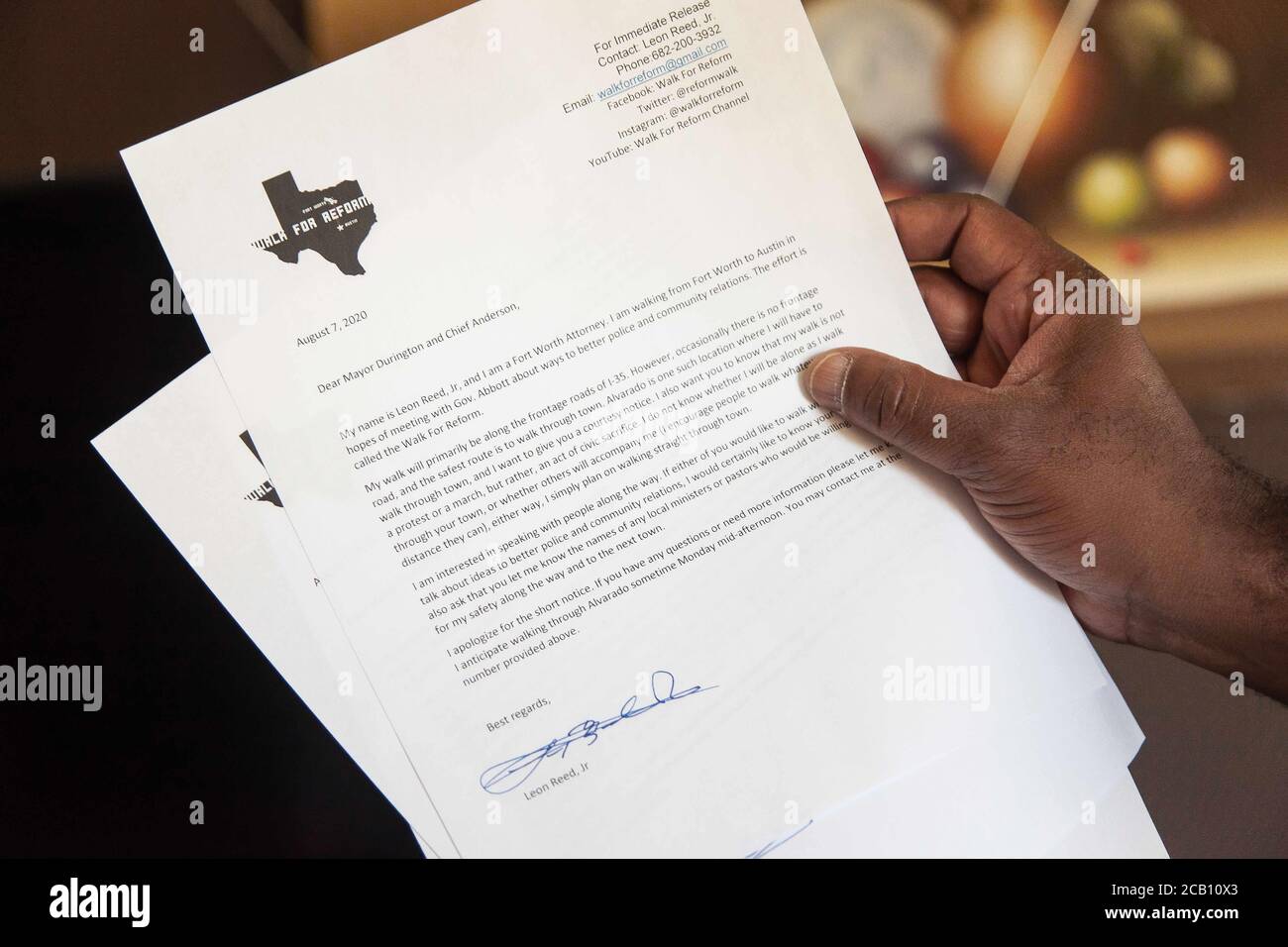 Ft Worth, TX, USA. August 2020. August 2020: Leon Reed, Jr, hält einen Brief, den er den Bürgermeistern der kleinen Städte geben wird, durch die er gehen wird, während er sich auf einem 200 Meilen langen Spaziergang von Ft Worth nach Austin, TX, einschiffen wird, um einen Brief zu überbringen und seine Gedanken zur Polizeireform mit Gov zu besprechen. Greg Abbott. Da er nicht sicher ist, wann er ankommen wird, hat er noch kein Treffen mit dem Gouverneur eingerichtet. Abbott, und er hofft, dass der Gouverneur ihn sehen wird. Leon ist seit 16 Jahren Strafverteidiger in Ft Worth und hofft, dass seine Ideen zu Veränderungen führen werden. Der Name seines Spaziergangs heißt Walk for Reform. Stockfoto