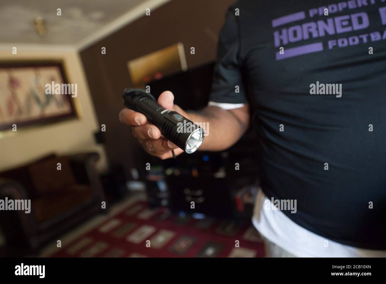 Ft Worth, TX, USA. August 2020. 8. August 2020: Leon Reed, Jr, hält seine Taschenlampe hoch, die er mit sich bringen wird, als er sich auf einen 200 Meilen langen Spaziergang von Ft Worth nach Austin, TX, aufmacht, um einen Brief zu überbringen und seine Gedanken zur Polizeireform mit Gov zu besprechen. Greg Abbott. Da er nicht sicher ist, wann er ankommen wird, hat er noch kein Treffen mit dem Gouverneur eingerichtet. Abbott, und er hofft, dass der Gouverneur ihn sehen wird. Leon ist seit 16 Jahren Strafverteidiger in Ft Worth und hofft, dass seine Ideen zu Veränderungen führen werden. Der Name seines Spaziergangs heißt Walk for Reform. (Bild: © Leslie Spurloc Stockfoto