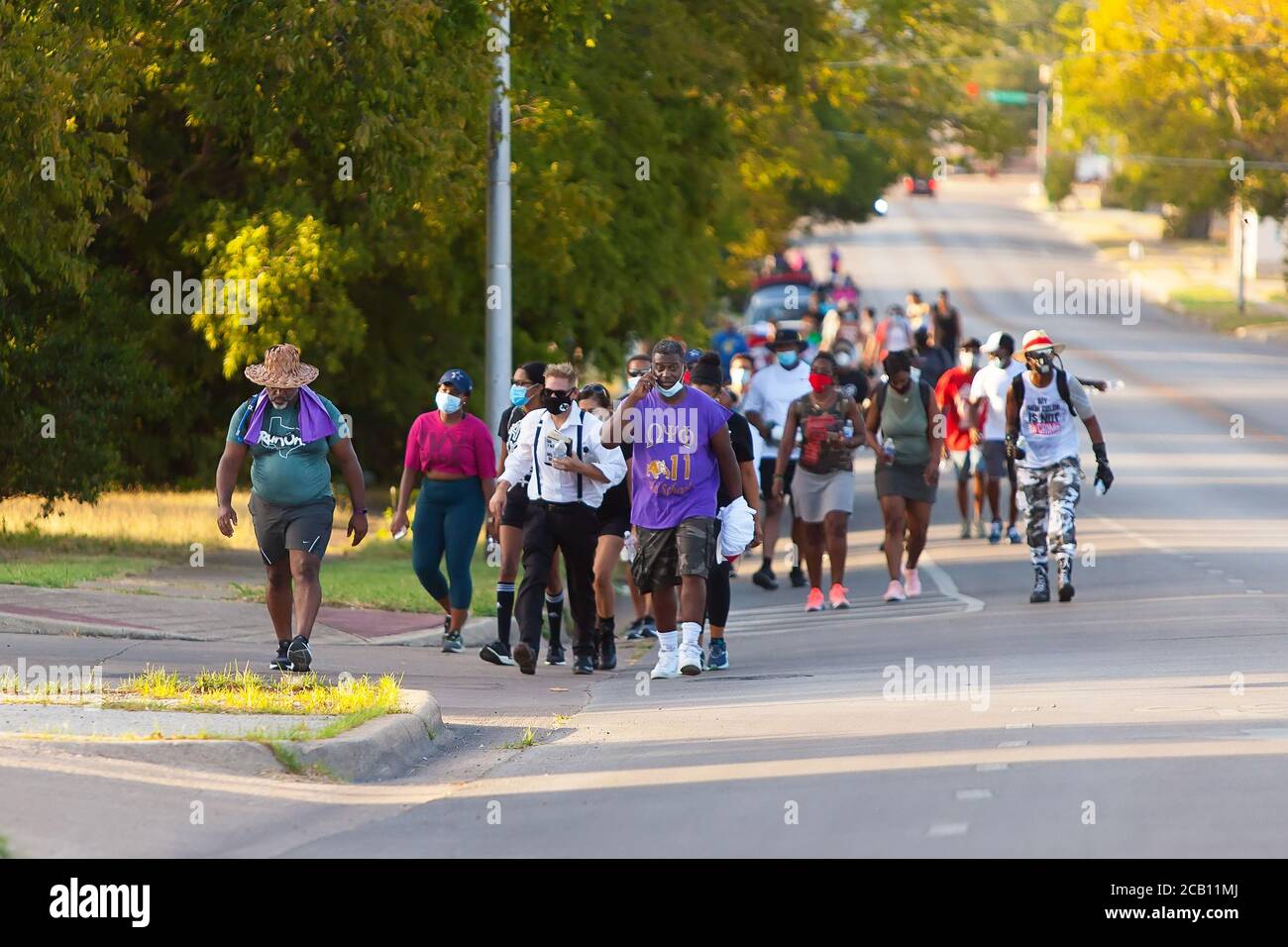 Ft Worth, TX, USA. August 2020. 9. August 2020: Eine Gruppe von Leuten geht mit Leon Reed, Jr. vom Rathaus zum Atatiana Jefferson Wandbild. Heute ist die erste Etappe Leon's 200 Meile zu Fuß von Ft Worth nach Austin, TX, um einen Brief zu liefern und seine Gedanken über die Polizeireform mit Gov zu diskutieren. Greg Abbott. Da er nicht sicher ist, wann er ankommen wird, hat er noch kein Treffen mit dem Gouverneur eingerichtet. Abbott, und er hofft, dass der Gouverneur ihn sehen wird. Leon ist seit 16 Jahren Strafverteidiger in Ft Worth und hofft, dass seine Ideen zu Veränderungen führen werden. Kredit: Leslie Spurlock/ZUMA Wire/Alamy Live Nachrichten Stockfoto