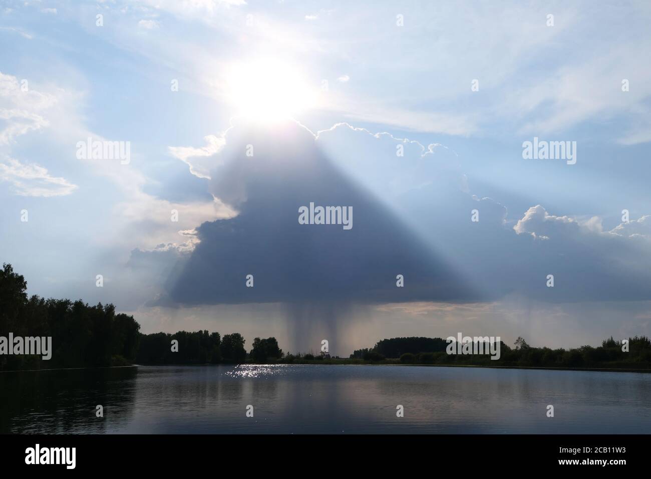 Regenwolke mit Sonne über dem See Stockfoto