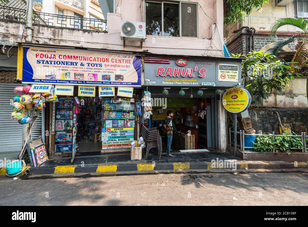 Mumbai, Indien - 22. November 2019: Straßenansicht von Mumbai an sonnigen Tagen mit Cafés und Geschäften in Mumbai (umgangssprachlich bekannt als Bombay), Indien. Stockfoto