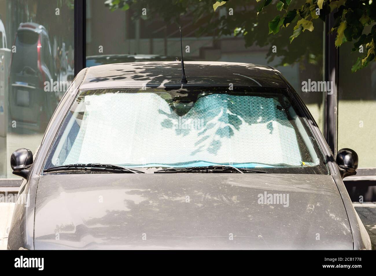 Die Windschutzscheibe des Autos mit schützenden reflektierenden Sonnenschutz  Oberfläche in dem Auto auf der Straße mit Sonnenstrahlen geparkt. Methode  zum Schutz von Sonnenstrahlen Auto beheizt Stockfotografie - Alamy