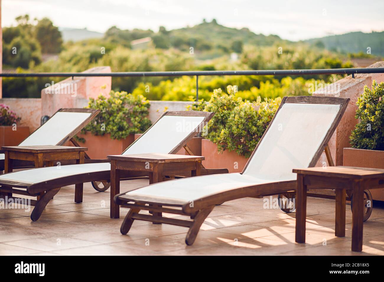 Leere Holzliegen in einer Reihe im Luxushotel. Sonnenliege zum Sonnenbaden. Stockfoto