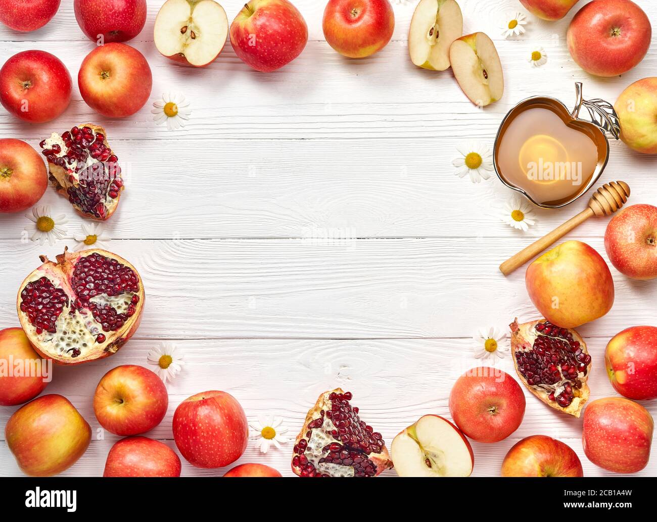 Rosh hashanah (jüdisches Neujahrsfest) Konzept. Traditionelle Symbole. Äpfel, Honig und Granatäpfel auf weißem Holzhintergrund. Stockfoto