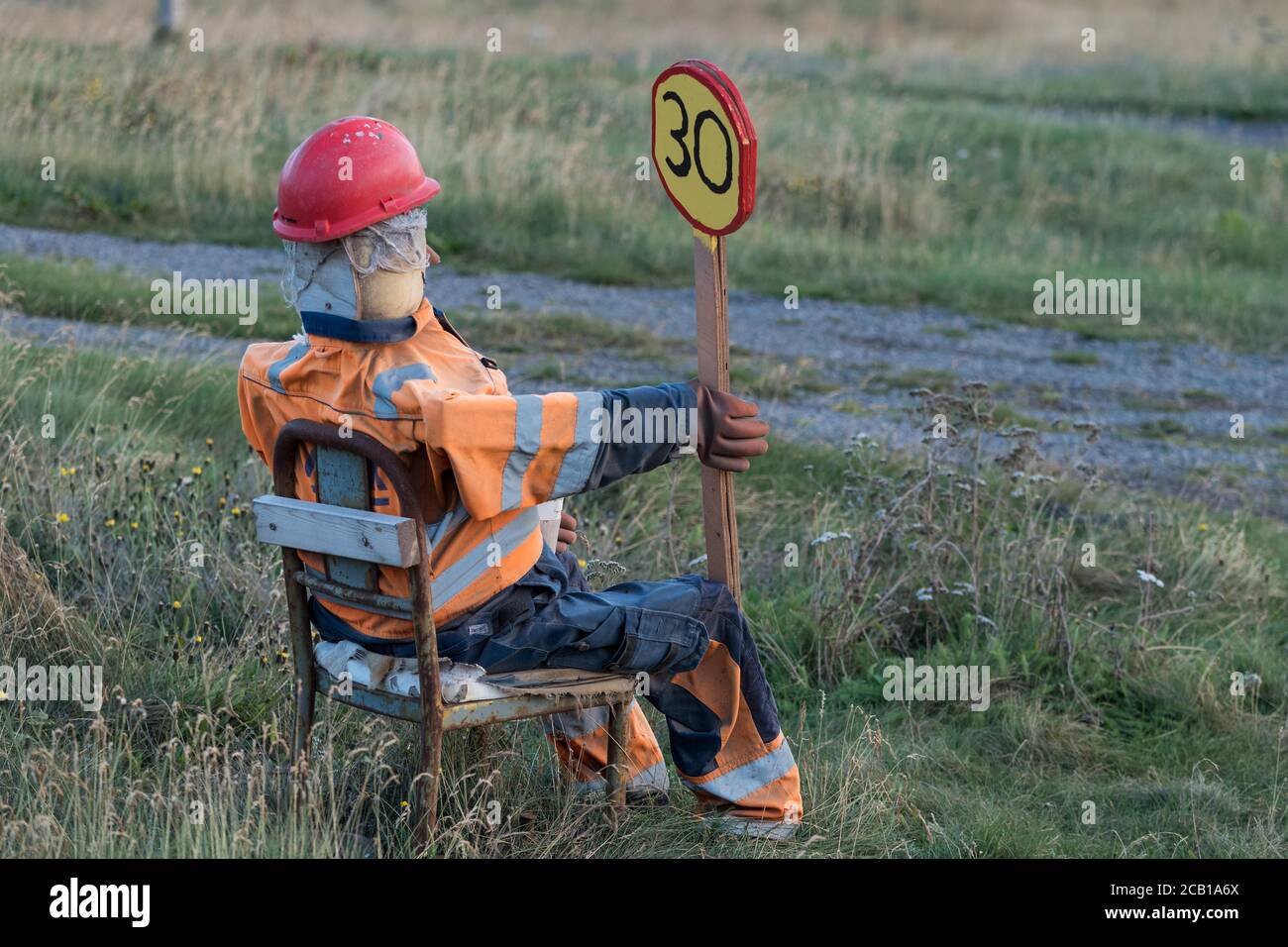 Puppe im Straßenarbeiterkostüm mit Schild, Warnung vor Geschwindigkeitsbegrenzung in der Umgebung, Hvallatur, Westfjorde, Island Stockfoto