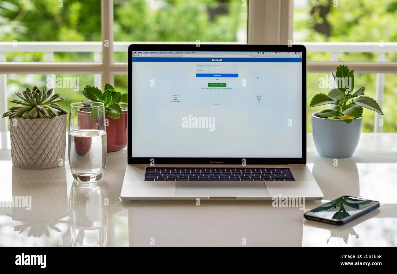 Laptop, Apple MacBook Pro mit iPhone X am Schreibtisch, mit Website Facebook, Deutschland Stockfoto