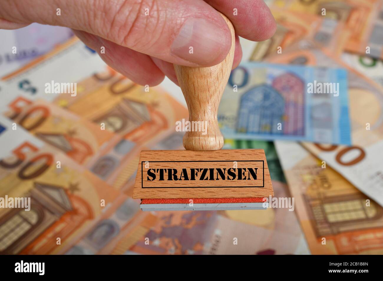 FOTOMONTAGE, Symbolbild Negatives Interesse, Stempel mit Aufschrift STRAFZINSEN, auf EURO-Banknoten, Deutschland Stockfoto