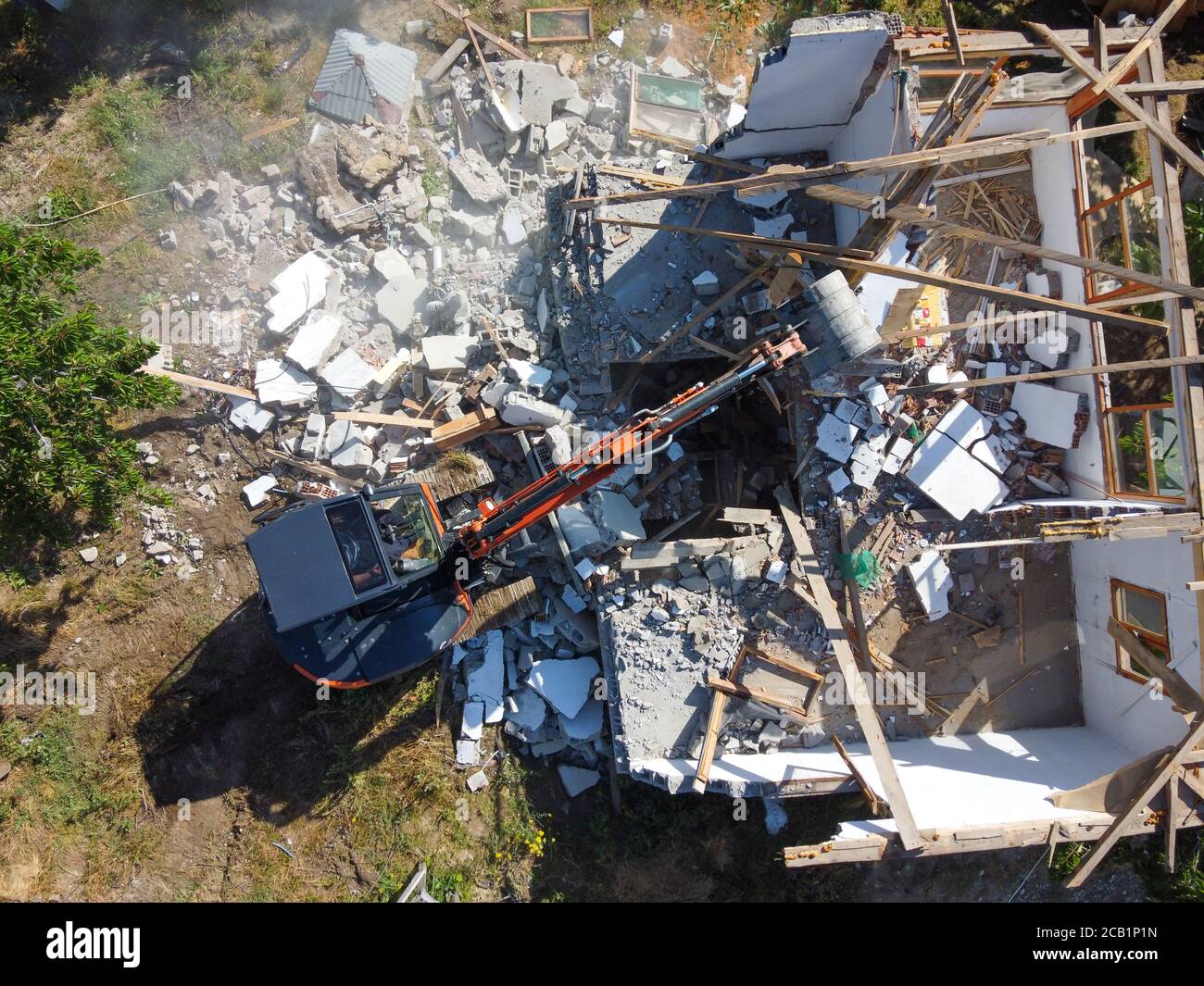 Zerstörung des alten Hauses mit Eimer Bagger im Dorf. Eine zerstören Die Zerstörung des alten Hauses der Bagger. Luftaufnahme Stockfoto