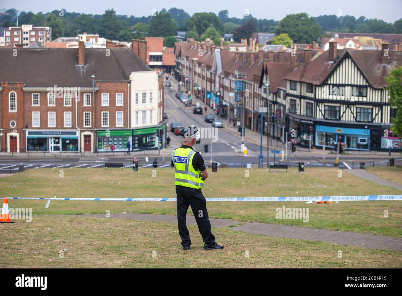 Polizist steht Wache an der Absperrung am Tatort mit Blick auf Englisch Stadt Stockfoto