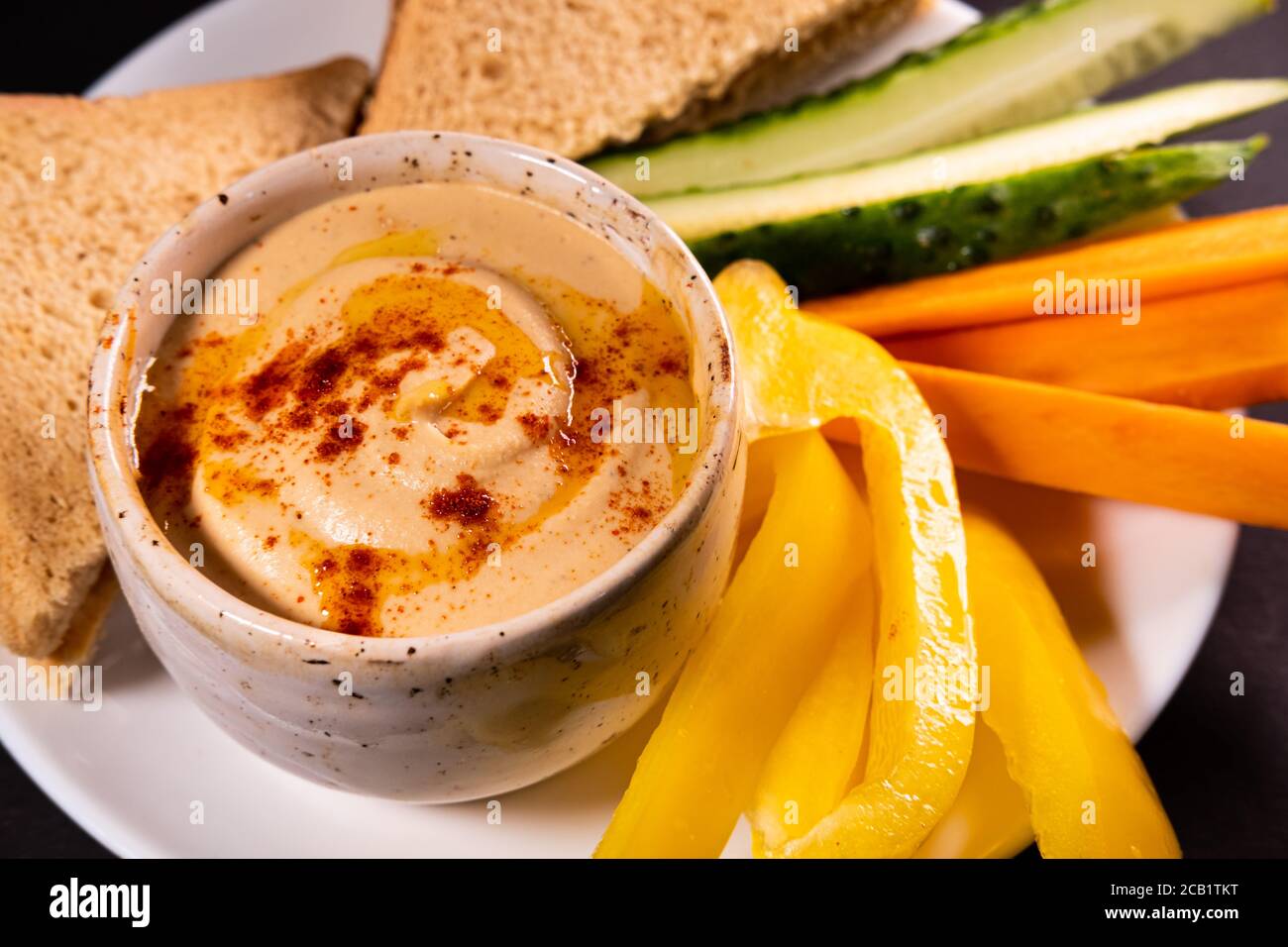 Hummus Dip und Gemüse auf einem Teller, Draufsicht mit Kopierraum. Gesunde vegane Mahlzeit oder Vorspeise, pflanzliche und vitaminreiche Lebensmittel Stockfoto
