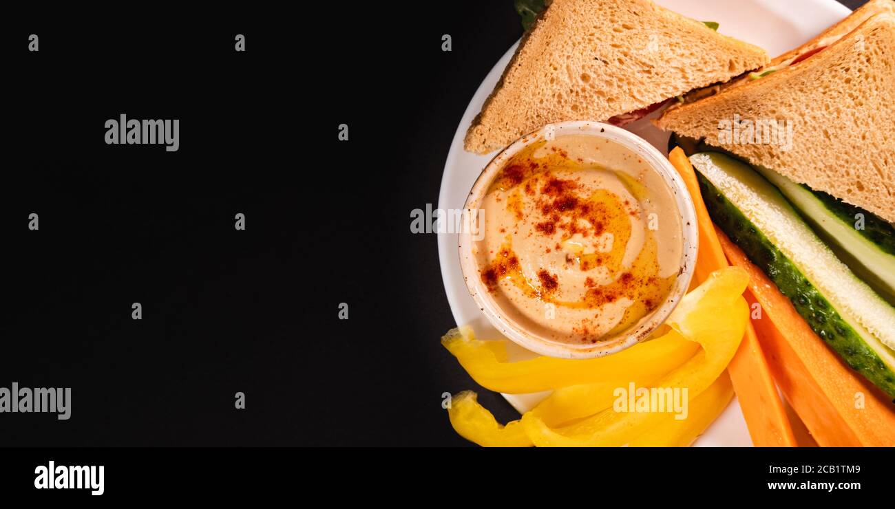 Hummus Dip, Gemüse und Brot auf einem Teller, Draufsicht mit Kopierraum. Gesunde vegane Mahlzeit oder Mittagessen, pflanzliche und vitaminreiche Lebensmittel Stockfoto