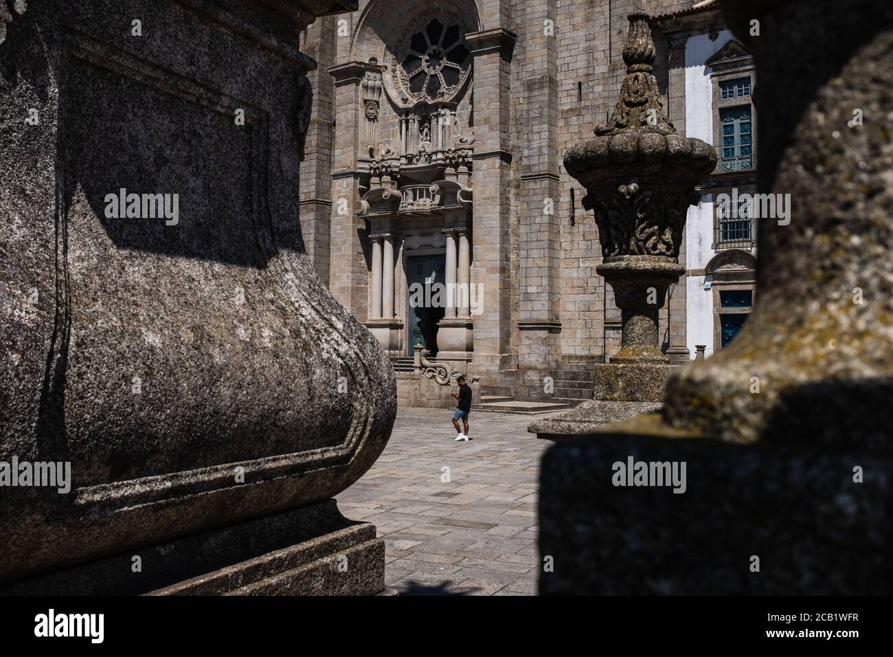 Ein Mann mit Schutzmaske geht an der Sé do Porto (Kathedrale von Porto) vorbei, einem Gebäude aus römisch-gotischer Struktur, das im 12. Jahrhundert erbaut wurde. Stockfoto