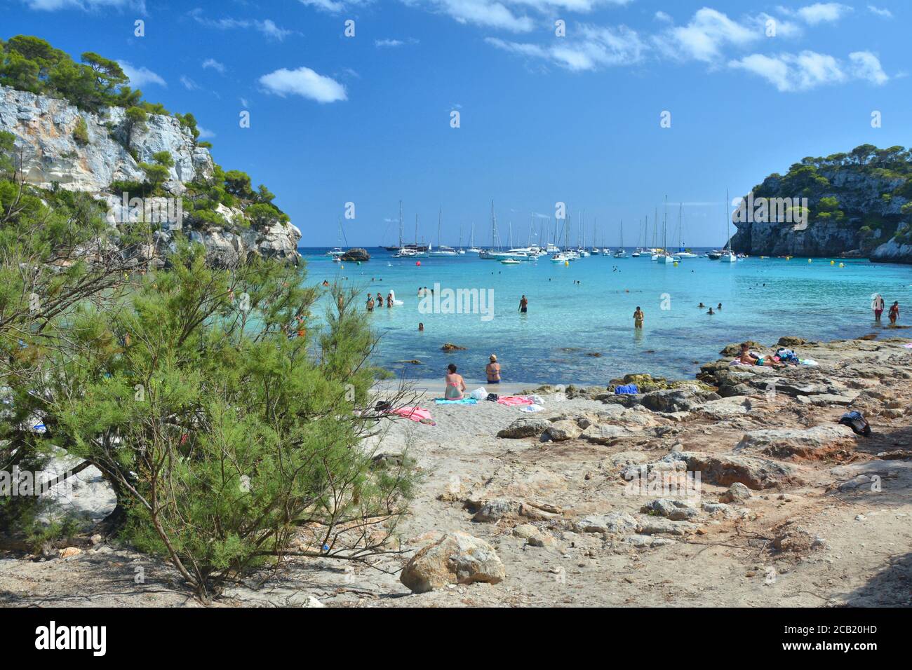 CALA MACARELLA, MENORCA, SPANIEN - 14. AUGUST 2018 : die Menschen genießen den Strand und das türkisfarbene Wasser in der Bucht Cala Macarella auf der Insel Menorca in Spanien. Stockfoto