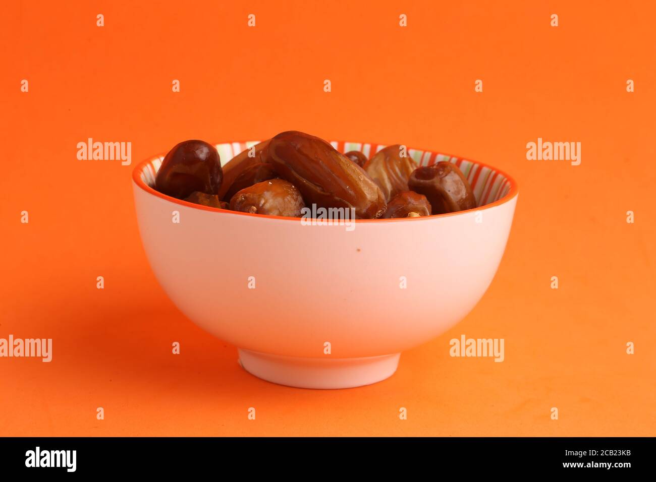 Süße und leckere Datteln in der Schale auf der Orange Oberfläche Stockfoto