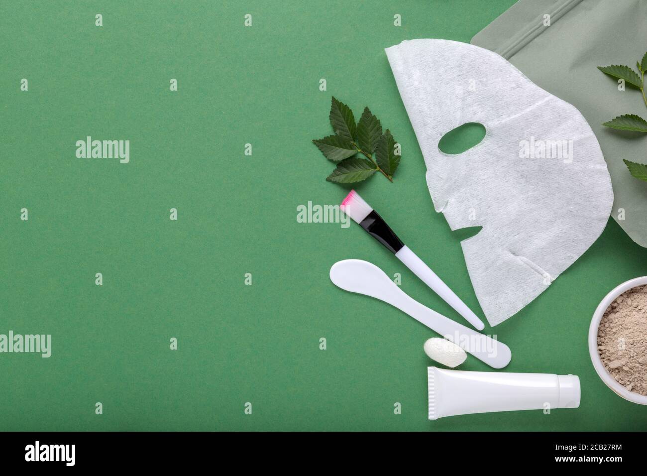 Stoff kosmetische Gesichtsmaske mit Set von Kosmetik Tonmaske Spatel und Pinsel, feuchtigkeitsspendende Creme in Tube. Beauty Spa-Behandlungen für Gesichtsbehandlungen Stockfoto
