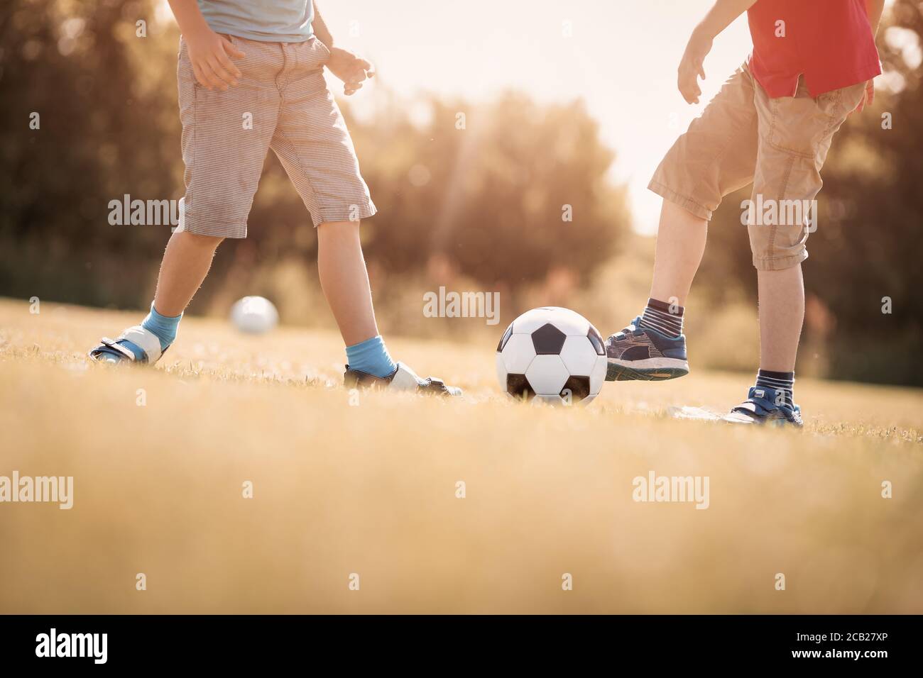 Jungen Fußball spielen auf dem Feld mit Toren Stockfoto