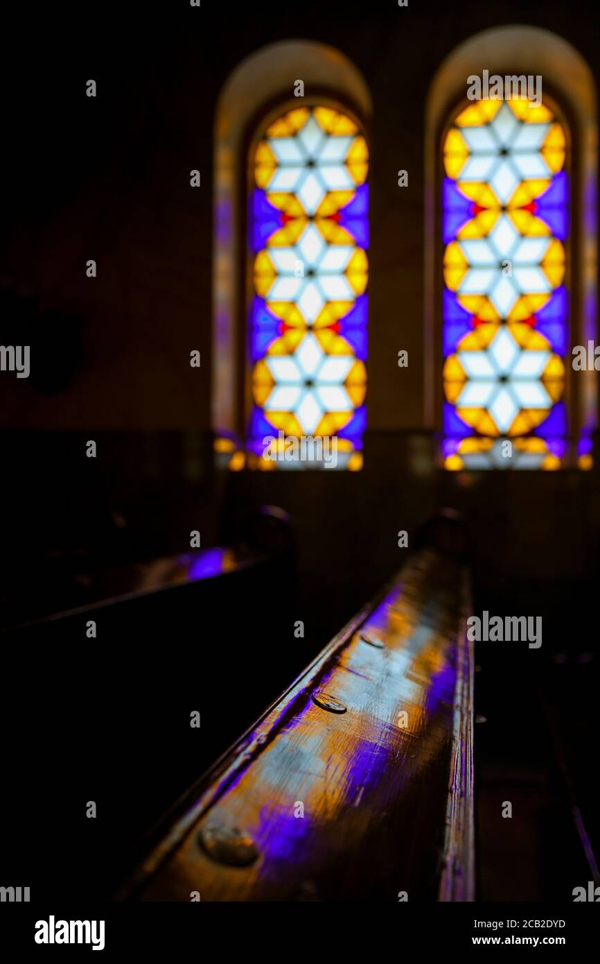 BUDAPEST, UNGARN - 30. März 2017: Buntglasfenster und farbige Lichtreflexion auf Holzbänken in der Dohany Street Synagoge in Budapest Stockfoto