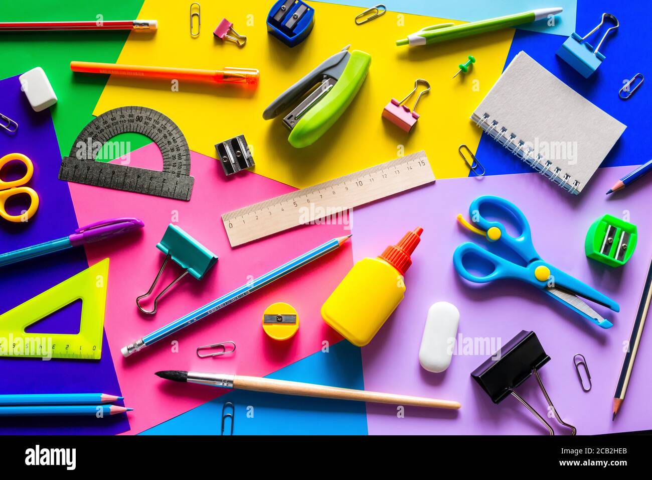 Verschiedene Accessoires für das Studium auf mehrfarbigem Hintergrund. Zurück zum Schulkonzept Stockfoto