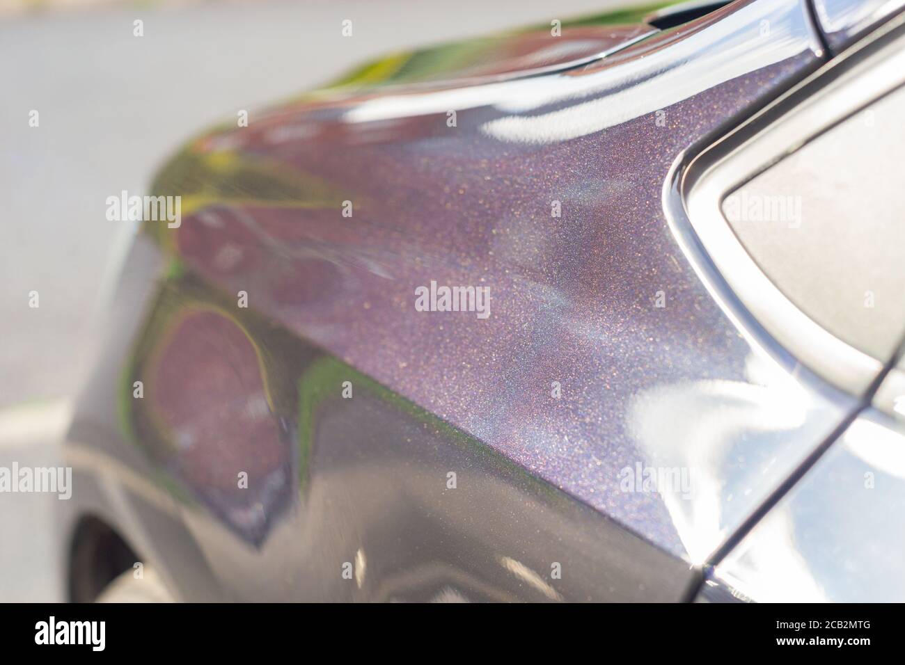Frisch polierte und gewachste Karosserie eines Autos mit schwarzer Perlmutt- Farbe. Sie erscheint aus der Ferne schwarz, hat aber einen funkelnden  purpurnen Glanz aus nächster Nähe Stockfotografie - Alamy