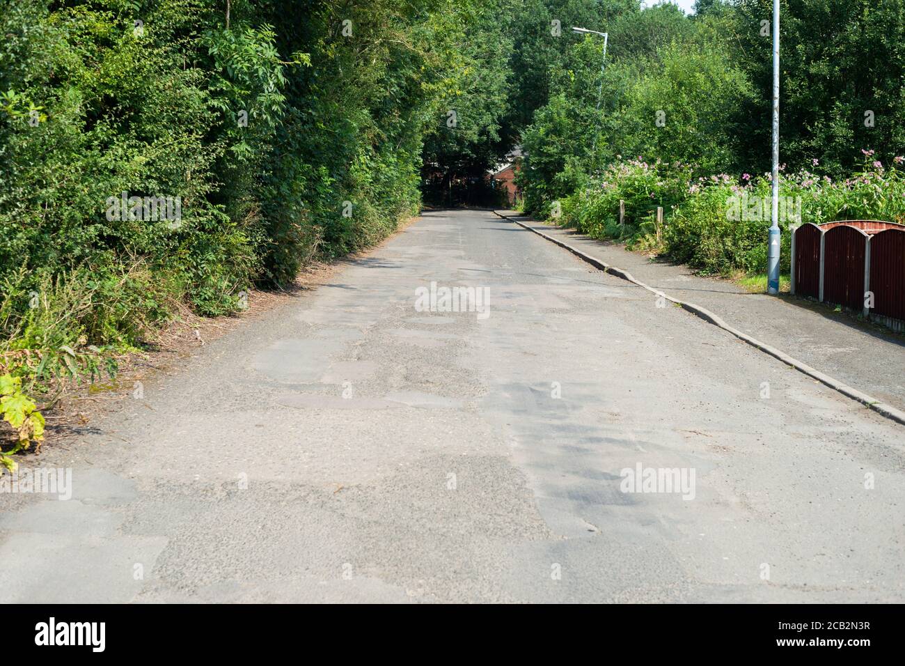 Beispiel einer schlecht reparierten Straße in Großbritannien mit Schlaglöchern und unebenem Straßenbelag. Mount Sion Road / Sion Street, Radcliffe, Manchester Großbritannien Stockfoto