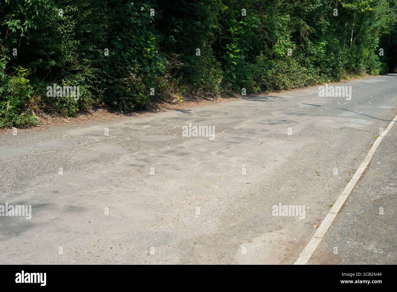 Beispiel einer schlecht reparierten Straße in Großbritannien mit Schlaglöchern und unebenem Straßenbelag. Mount Sion Road / Sion Street, Radcliffe, Manchester Großbritannien Stockfoto