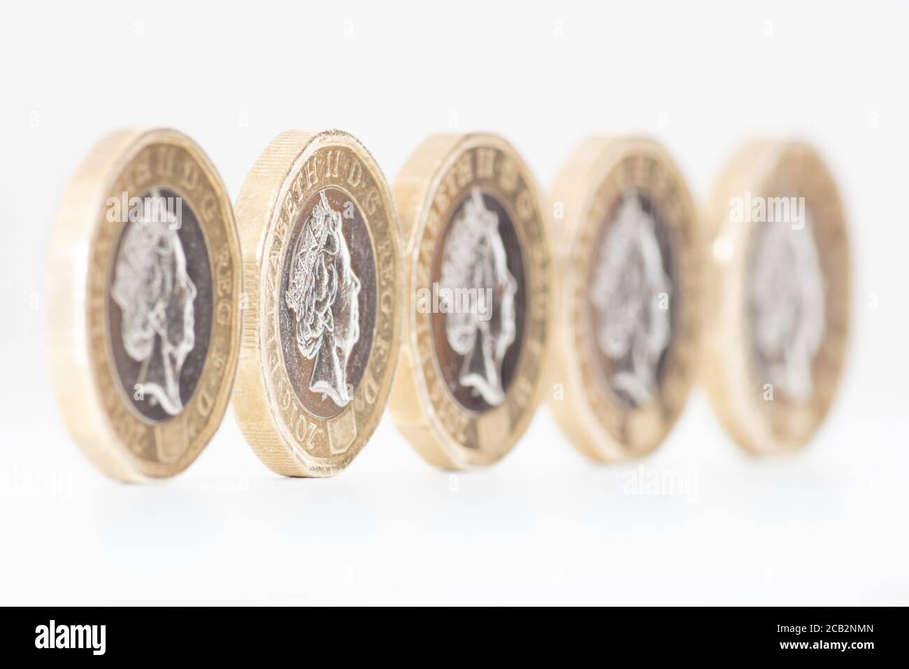 £1 Münzen des Pfund Sterling aufgereiht in einer Reihe. 2016 Neugestaltung der Pfund-Münze mit 12-seitigem oder zweieckigen Außenkante. GROSSBRITANNIEN, GROSSBRITANNIEN, GB, GROSSBRITANNIEN Stockfoto