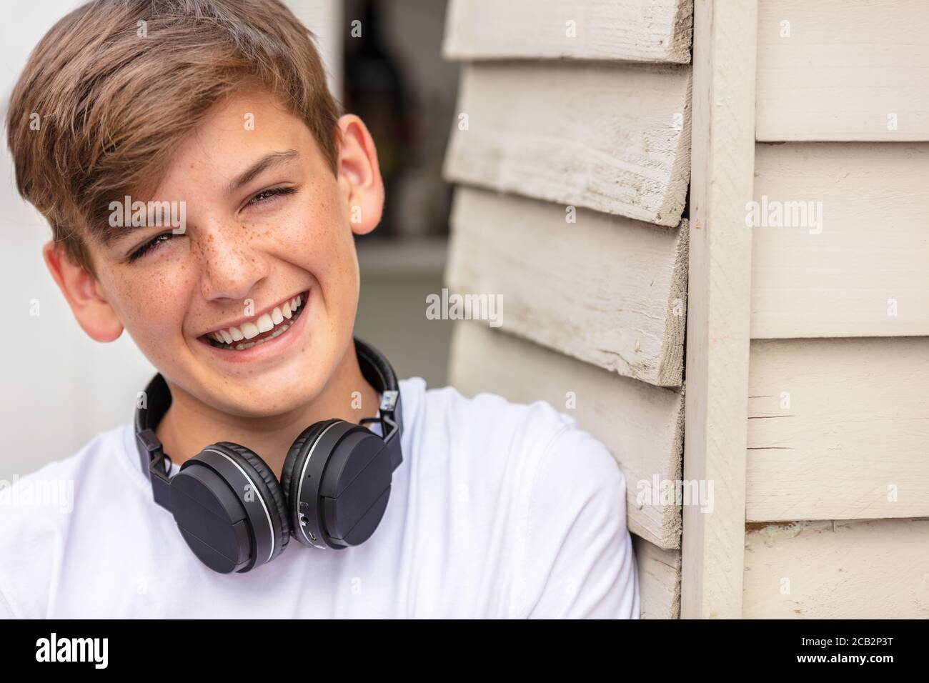 Teenager glücklich lächelnd draußen tragen bluetooth kabellose Kopfhörer Stockfoto