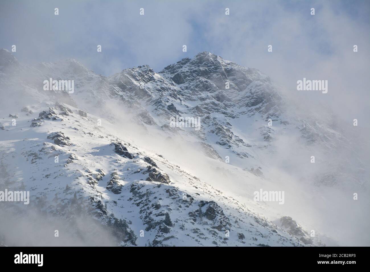 Tatra Berge tauchen aus den Wolken auf. Malerische Winterlandschaft des Tatra Nationalparks in Polen. Stockfoto