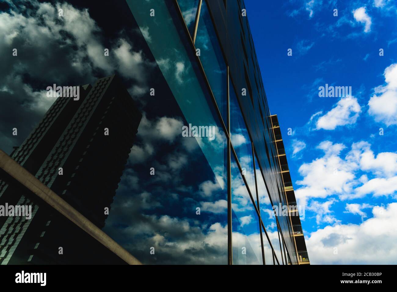 Ein tiefblauer Himmel spiegelt sich in den sauberen Glaswänden eines Gebäudes in einer Großstadt wider. Stockfoto