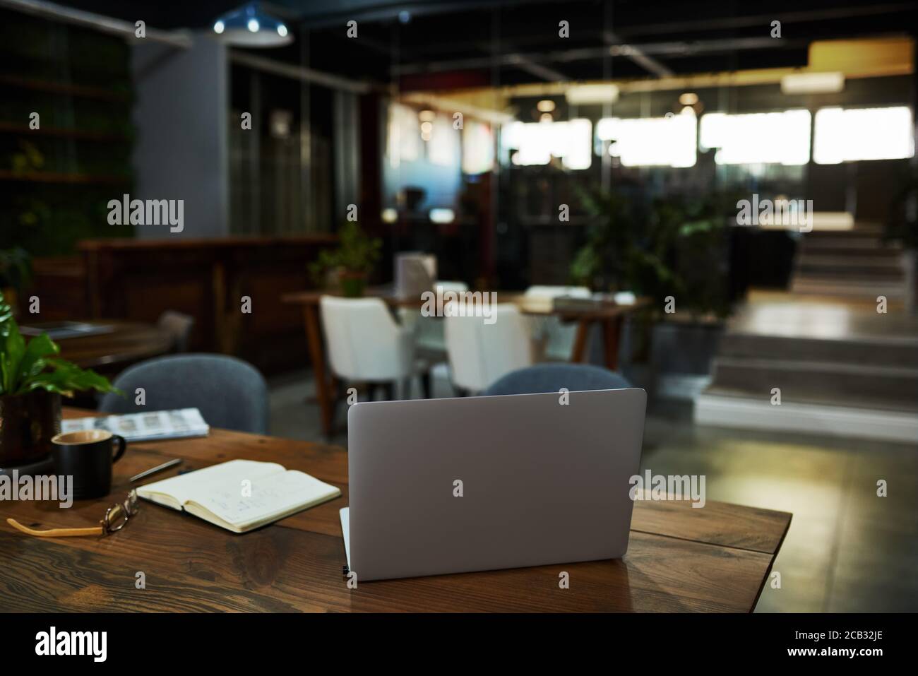 Laptop sitzt auf einem Schreibtisch in einem Büro außerhalb der Geschäftszeiten Stockfoto