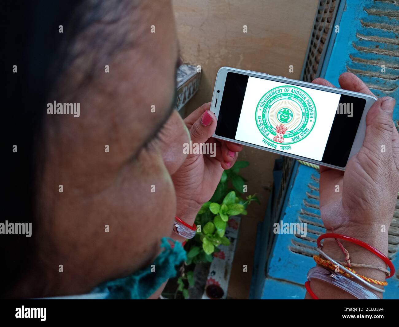 DISTRIKT KATNI, INDIEN - 23. MAI 2020: Frau hält Smartphone mit ausgestellten Regierung von andhra pradesh Symbol auf dem Bildschirm. Stockfoto