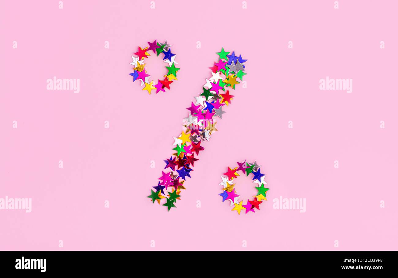 Rabatt-Symbol aus mehrfarbigen Sternen auf einem rosa Hintergrund. Ein Prozentzeichen, Weihnachtsverkäufe Stockfoto