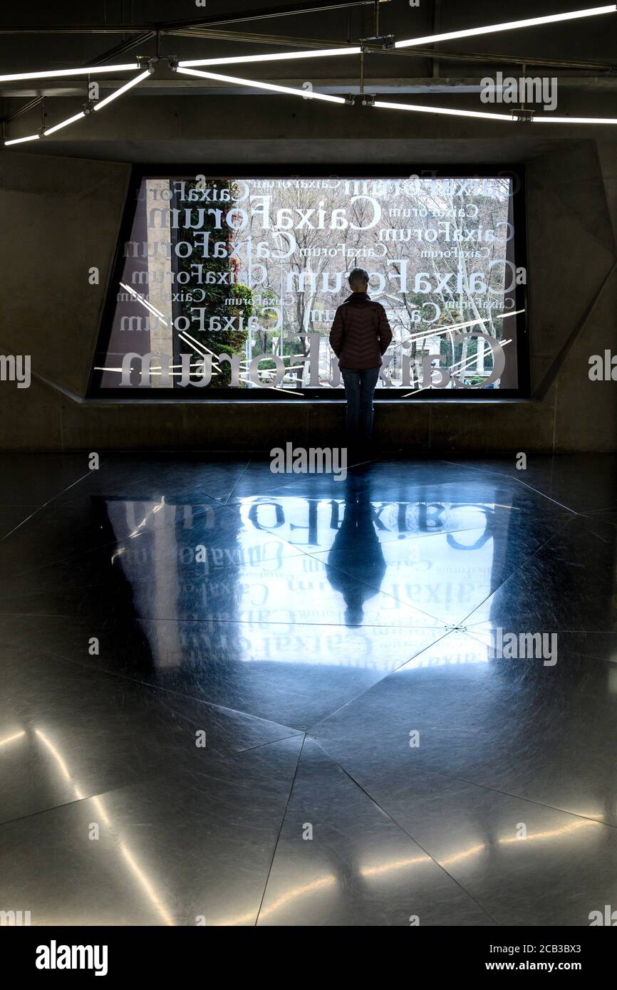 Ein Besucher nimmt den Blick aus einem Fenster in der Caixa Forum Gallery und dem Ausstellungszentrum Madrid, Spanien, auf. Stockfoto