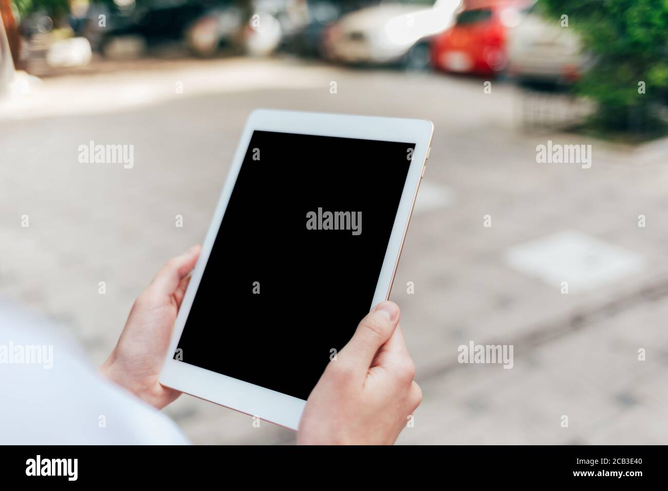 Frau, die im Freien ein digitales Tablet in den Händen hält Stockfoto