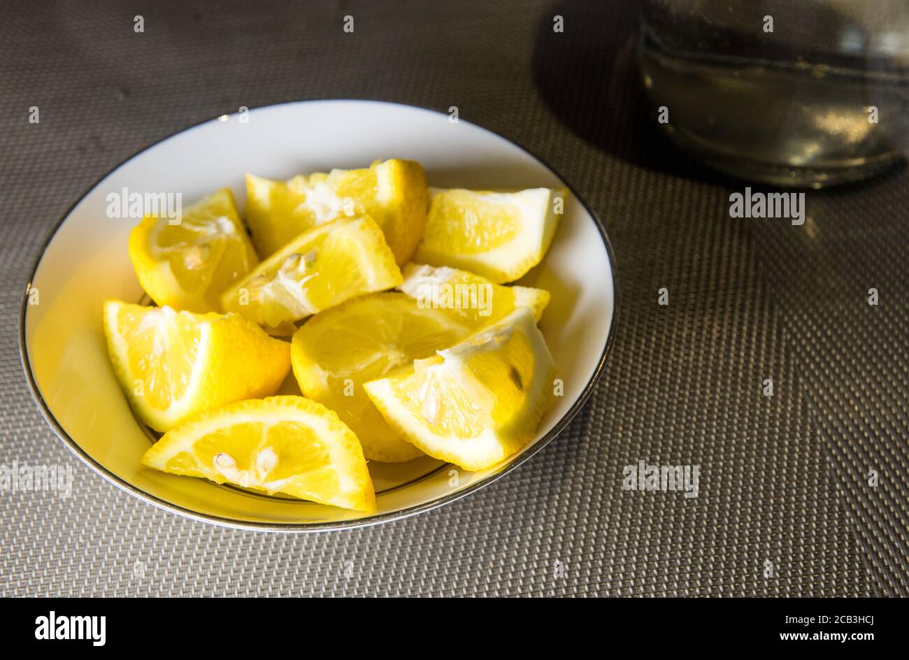 Zitronenscheiben in einer Schüssel serviert als Begleitung für eine Mahlzeit oder als Cocktail hinzuzufügen. Kühlung im Sommer und fügt Alkalinität Stockfoto