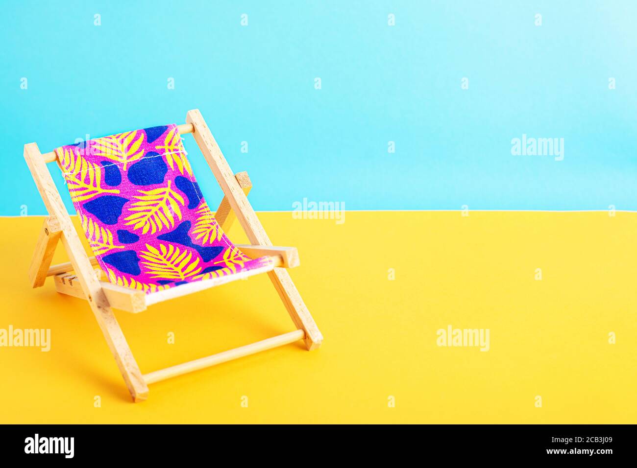 Strandliege auf gelbem Grund mit blauem Hintergrund. Stockfoto