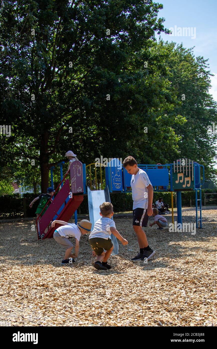 Eine Gruppe von kleinen Kindern, die als Gruppe in spielen Ein Spielplatz mit Klettergerüst im Hintergrund Stockfoto