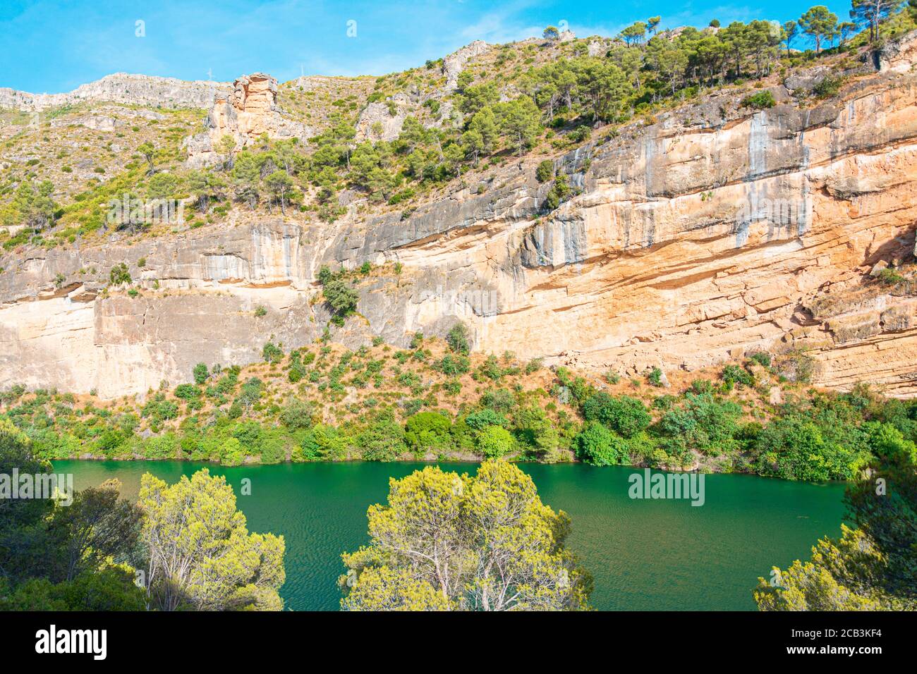 Blick auf eine Felswand neben einem Fluss Mit türkisfarbener Farbe eines Wassers Stockfoto