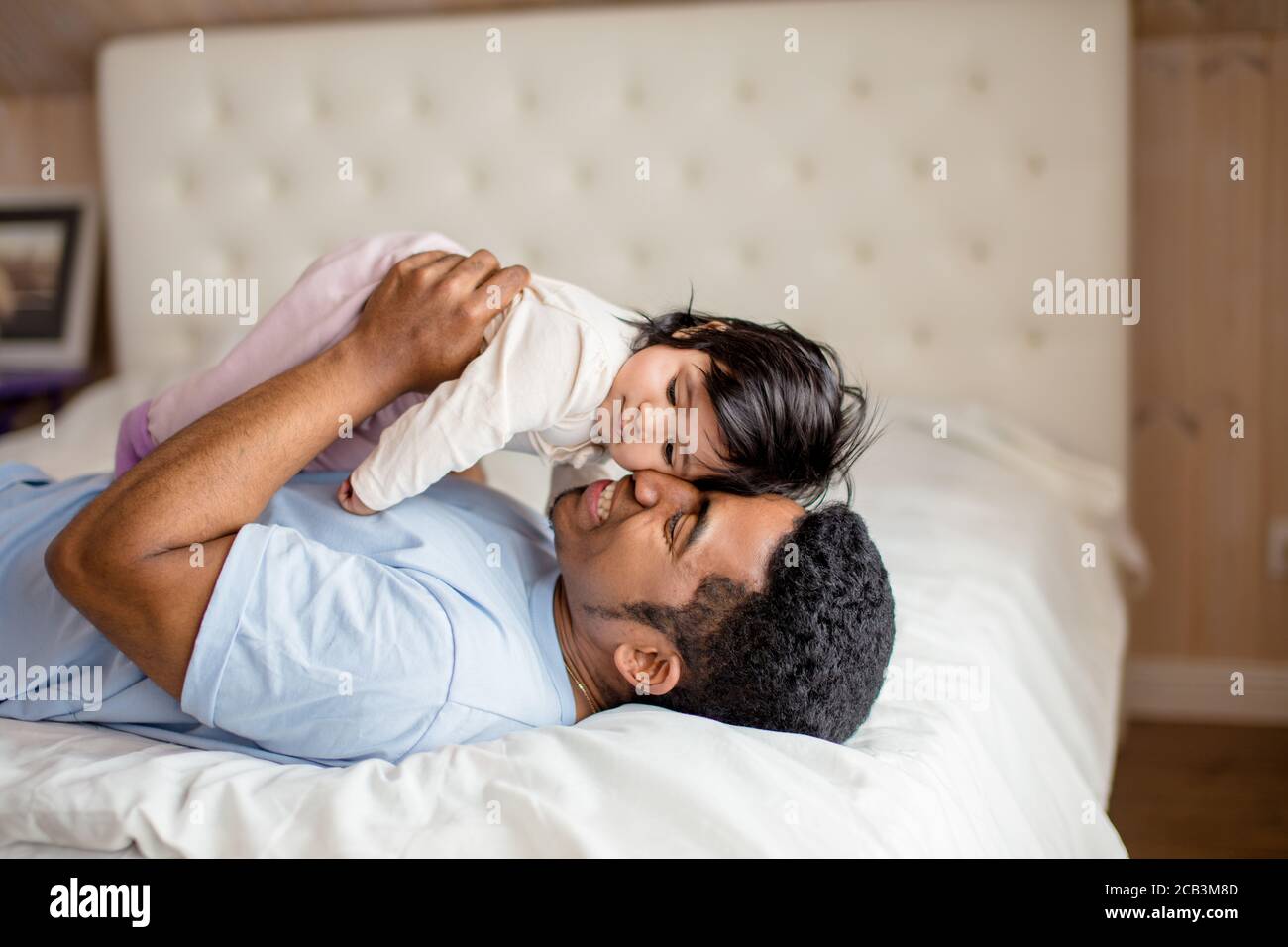 Glücklicher Vater umarmt sein süßes Kind, Liebe zwischen einer Tochter und einem Papa, Nahaufnahme Seitenansicht Foto Stockfoto
