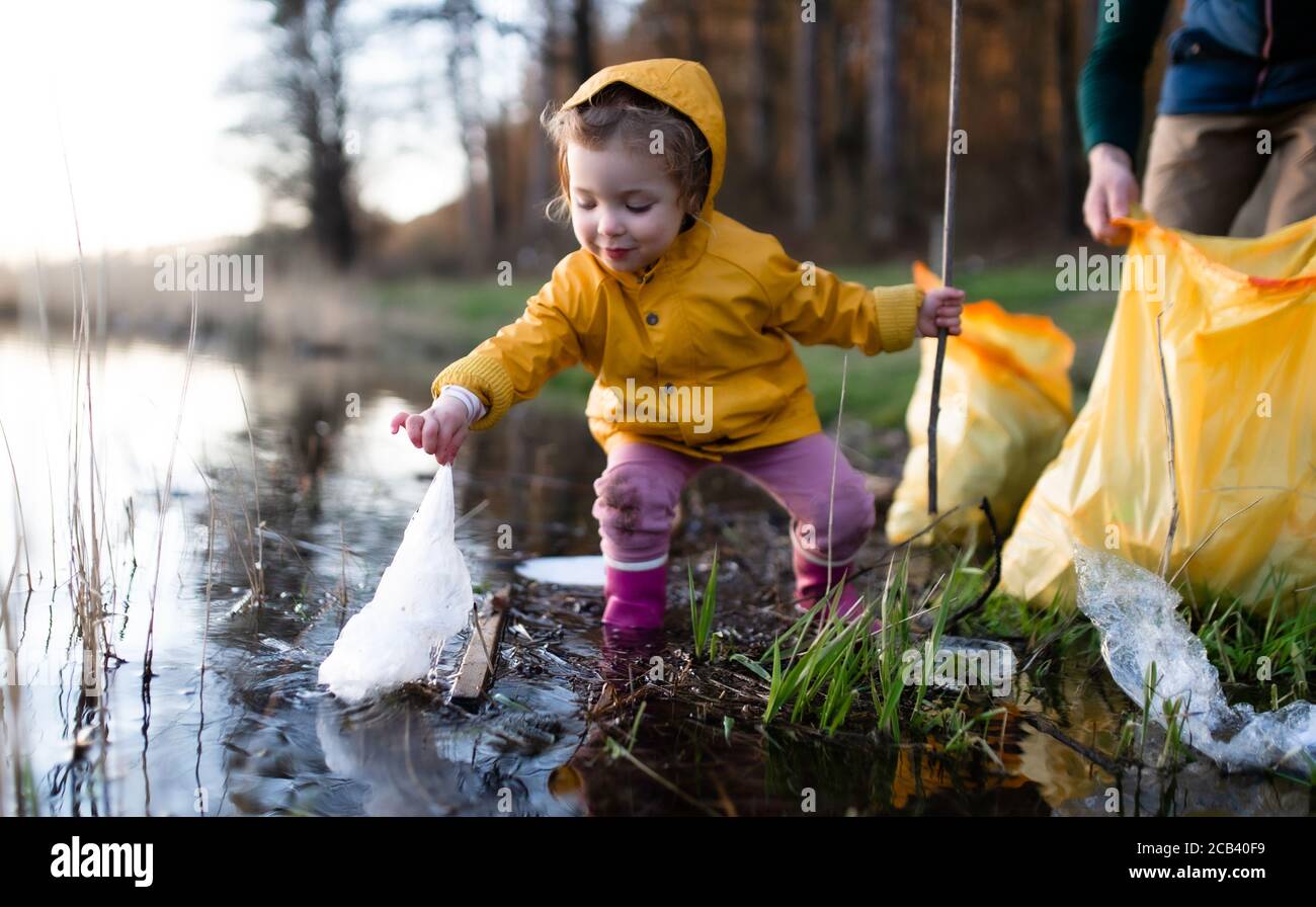 Vater mit kleiner Tochter sammeln Müll im Freien in der Natur, plogging Konzept. Stockfoto