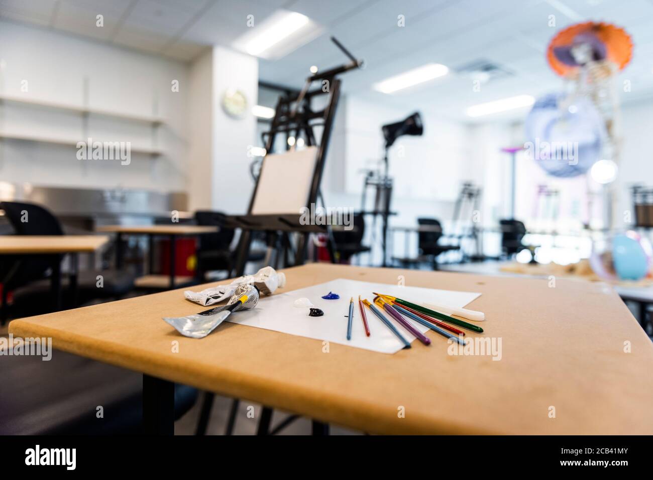 Kunstbedarf wie Farbe, Pinsel und Leinwände in einem Klassenzimmer. Stockfoto