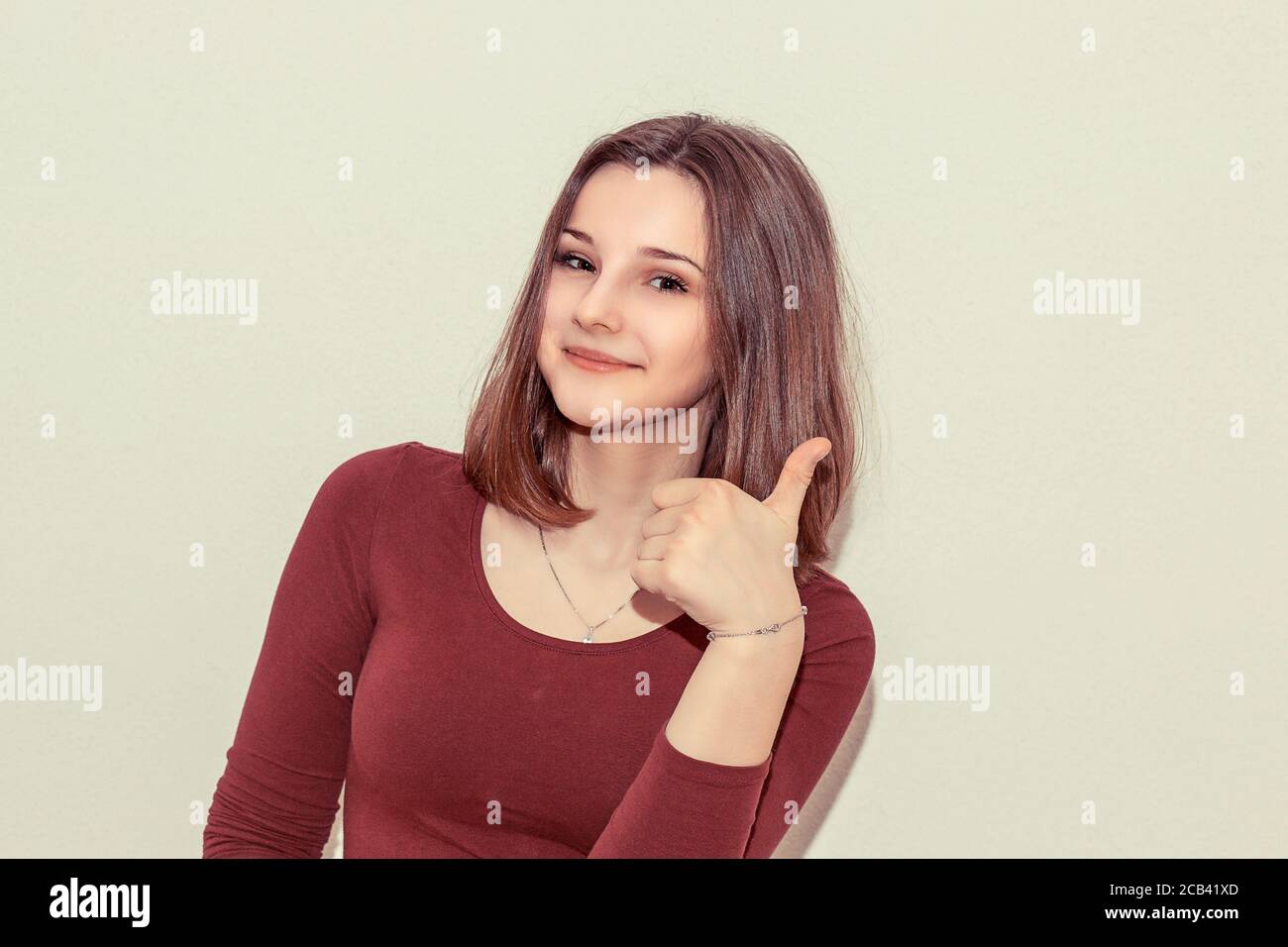 Junge Teenager-Frau zeigt Daumen hoch und lächelt vor der Kamera Auf weißem Hintergrund Stockfoto