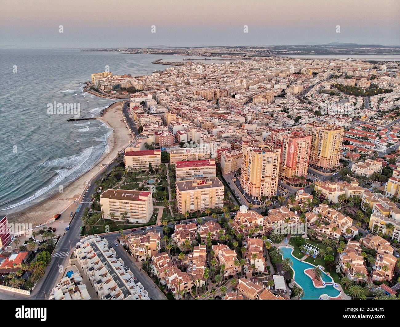 Luftpanoramabo von Torrevieja Stadtbild, felsige Küste Mittelmeer bei Sonnenaufgang, Salzsee oder Las Salinas, Bildansicht von oben. Pro Stockfoto