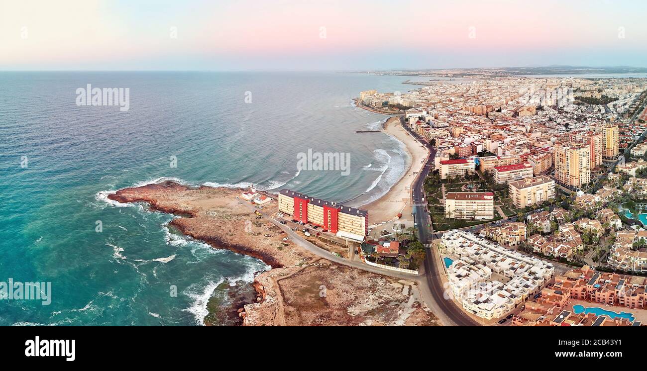 Luftpanoramabo von Torrevieja Stadtbild, felsige Küste Mittelmeer bei Sonnenaufgang, Salzsee oder Las Salinas, Bildansicht von oben. Pro Stockfoto