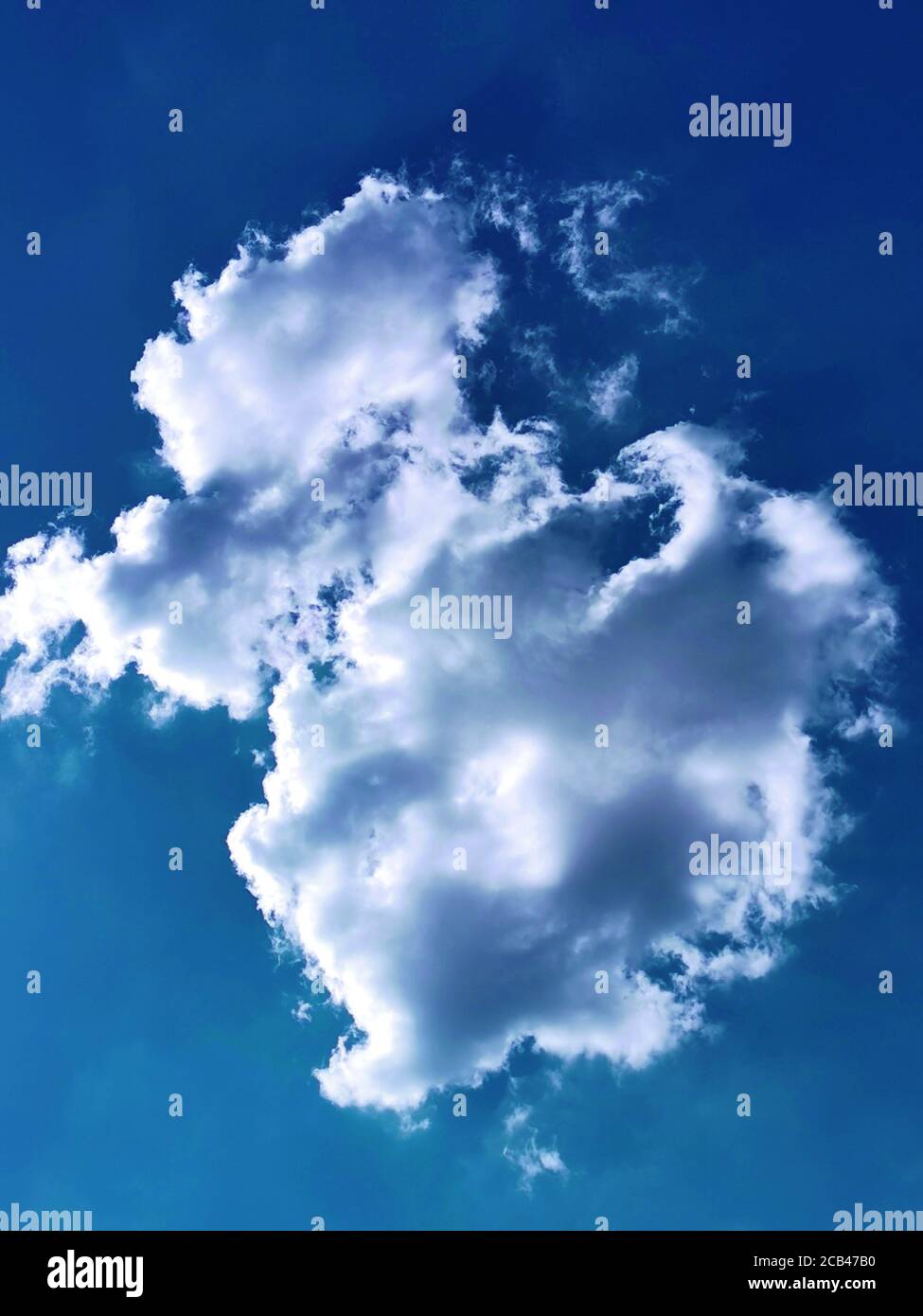 Einzelne flauschige Wolke am blauen Himmel Stockfoto