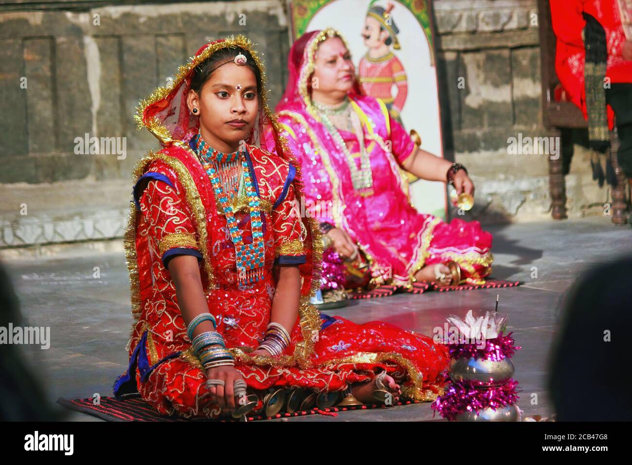 Udaipur, Indien - 24. Mai 2013: Zwei indische Frauen in Saree tanzen, während sie auf dem Boden sitzen Stockfoto