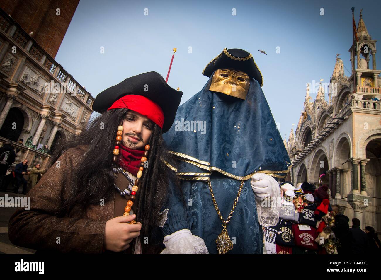 VENEDIG, ITALIEN - 28. JANUAR 2018: Ein Kind mit einem Piratenkostüm und ein Mann mit einer goldenen Maske und einem blauen Kostüm, während des Karnevals von Venedig mit San Marco Stockfoto