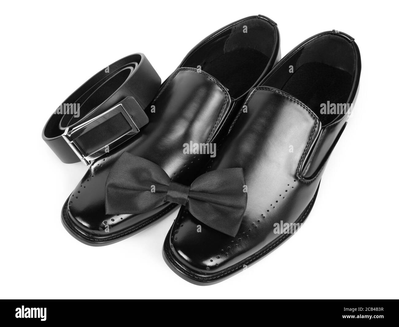 Nahaufnahme von schwarzen männlichen Schuhen, Fliege und Gürtel auf weißem Hintergrund Stockfoto